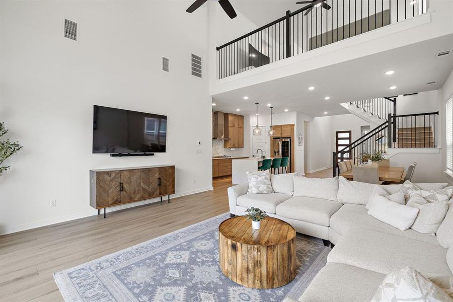 A striking two-story living area features an open floorplan connecting the kitchen, dining, and family spaces. A striking two-story living area features an open floorplan connecting the kitchen, dining, and family spaces.