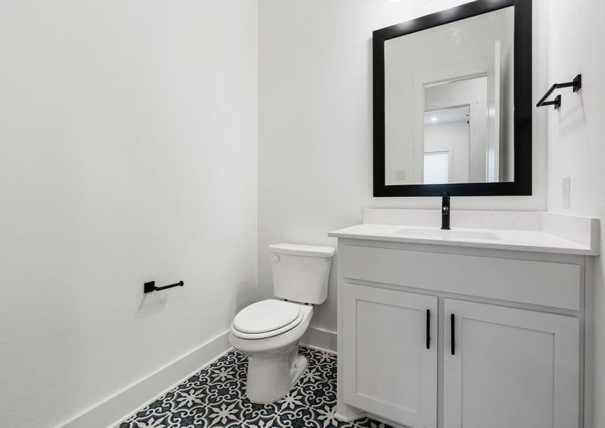 The half bathroom has gorgeous tile flooring.