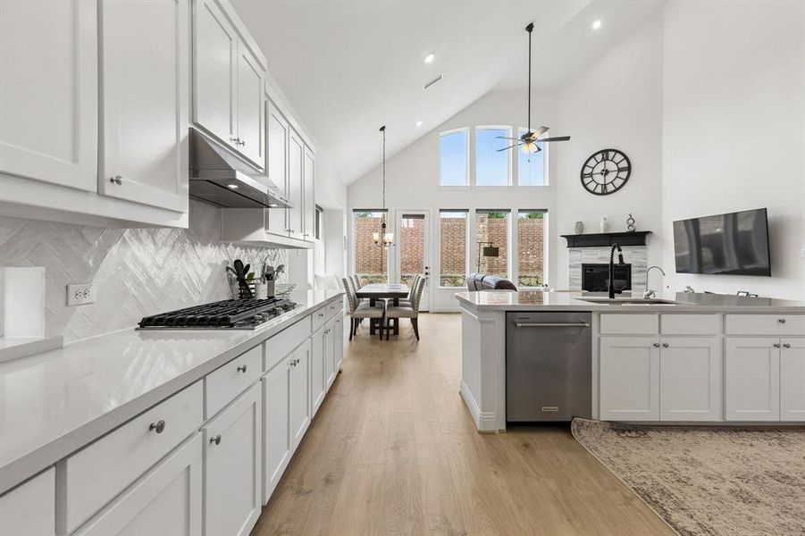 Kitchen featuring white shaker cabinetry, light countertops, and a herringbone-patterned tile backsplash