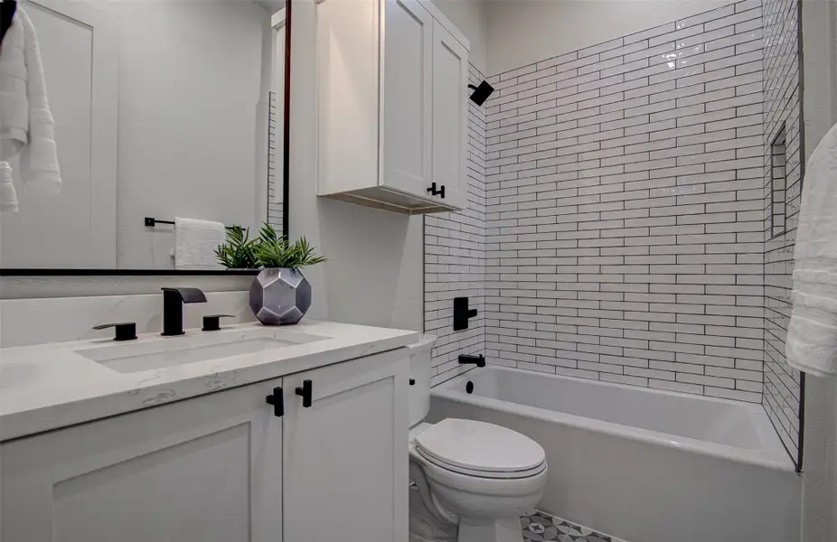 Bathroom featuring vanity, toilet, and tub / shower combination Bathroom featuring vanity, toilet, and tub / shower combination