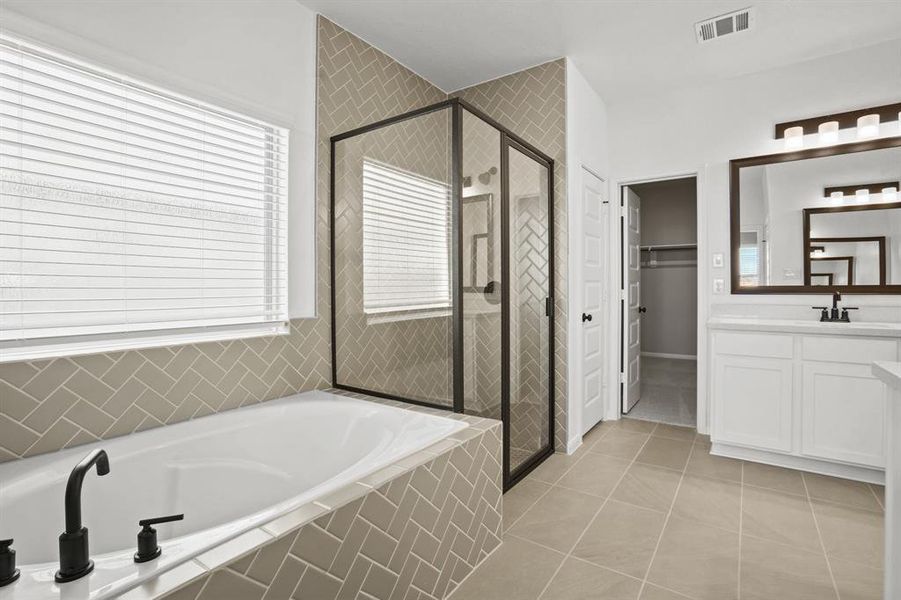 Relaxing owner's bath with soaking tub and shower