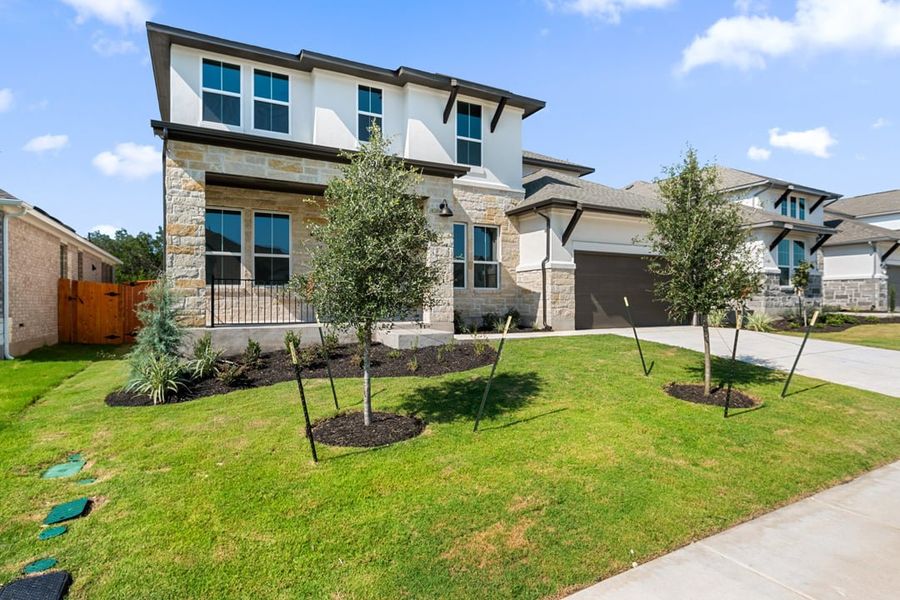 Front exterior of a new home in Capitol Collection at Lariat, Liberty Hill, TX, highlighting curb appeal (Image 2). Front exterior of a new home in Capitol Collection at Lariat, Liberty Hill, TX, highlighting curb appeal (Image 2).