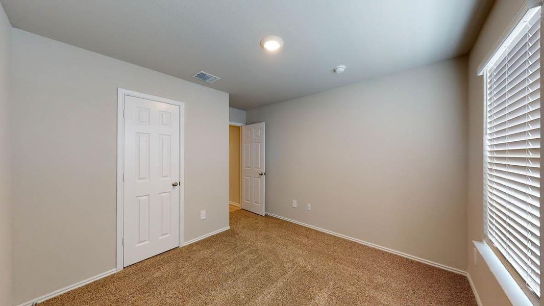 A well-lit bedroom with fresh carpeting, ready for personalization. A well-lit bedroom with fresh carpeting, ready for personalization.
