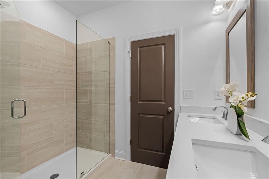 Primary Bathroom features walk in shower with frameless shower Door and additional linen closet *Images shown are from a decorated model of the same floor plan. Design selections and color packages will vary by home.*
