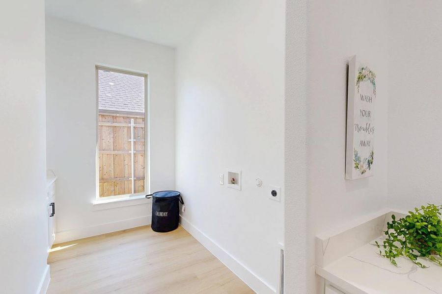 Washroom featuring electric dryer hookup, hookup for a washing machine, and light wood finished floors