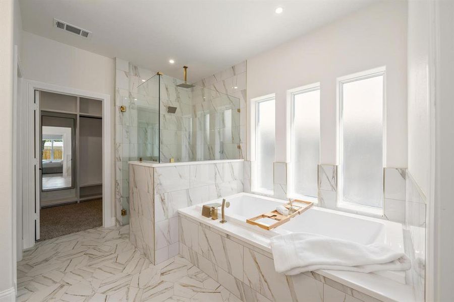 Bathroom with a marble finish shower, a garden tub, and recessed lighting Bathroom with a marble finish shower, a garden tub, and recessed lighting