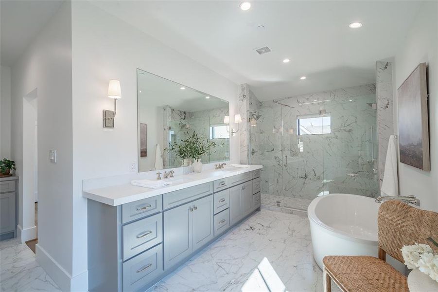 Primary bathroom featuring independent shower, bath, and double vanity