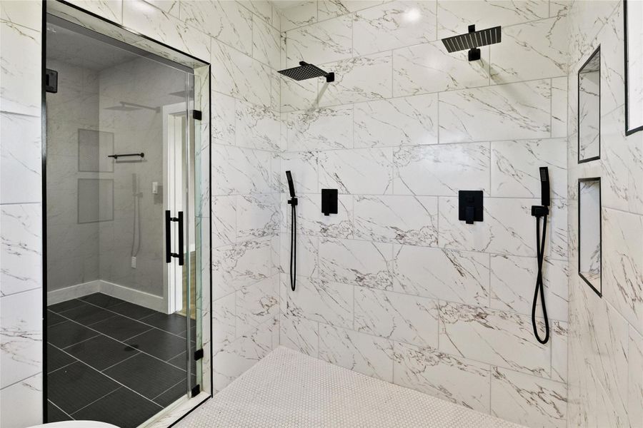 A stunning wet room serves as the centerpiece of the primary bath, combining a freestanding soaking tub and dual-head shower within a beautifully tiled space.
