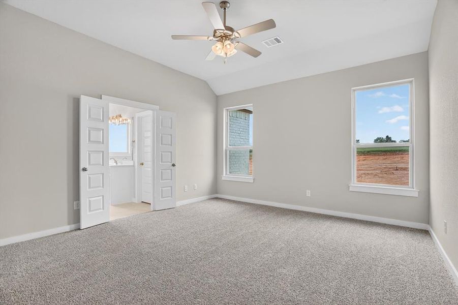 Spacious room featuring vaulted ceilings, light gray wall paint, and gray textured carpeting Spacious room featuring vaulted ceilings, light gray wall paint, and gray textured carpeting
