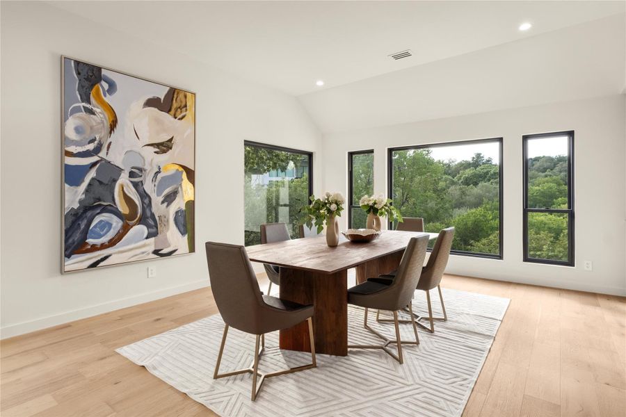 Dining room featuring vaulted ceiling, light wood-style floors, recessed lighting, and baseboards