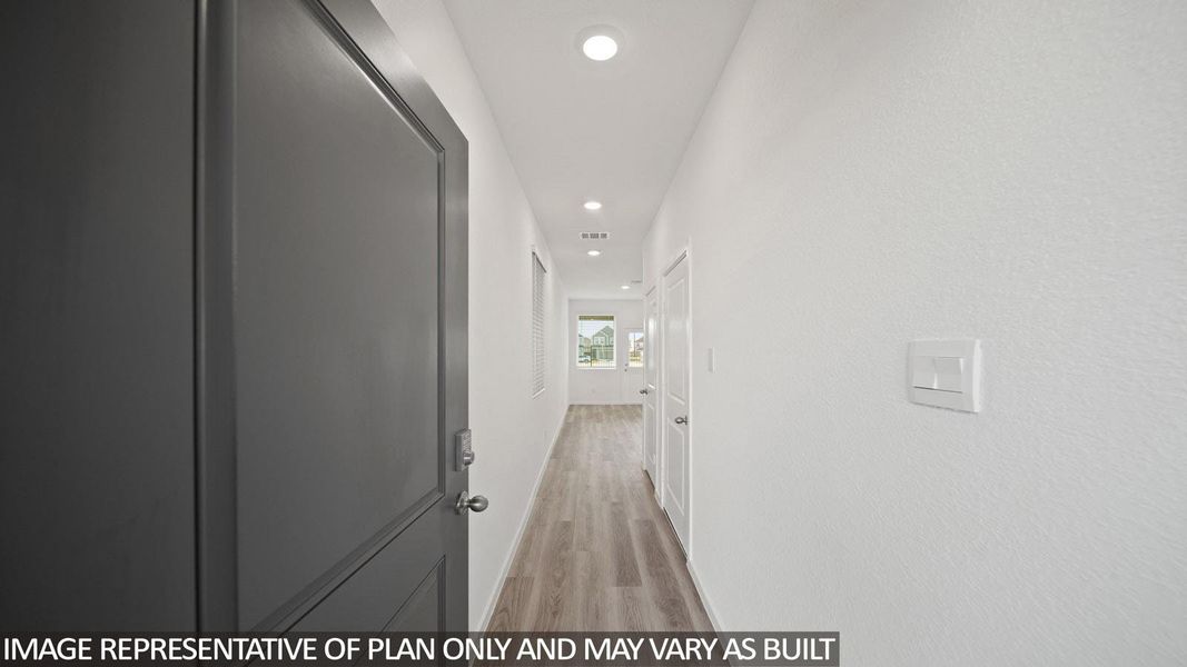 Entryway featuring a dark gray paneled door, light wood-finish flooring, recessed lighting, and white textured walls