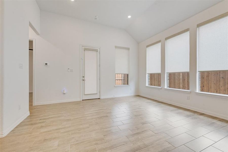 Spare room featuring vaulted ceiling, recessed lighting, and light wood-type flooring Spare room featuring vaulted ceiling, recessed lighting, and light wood-type flooring