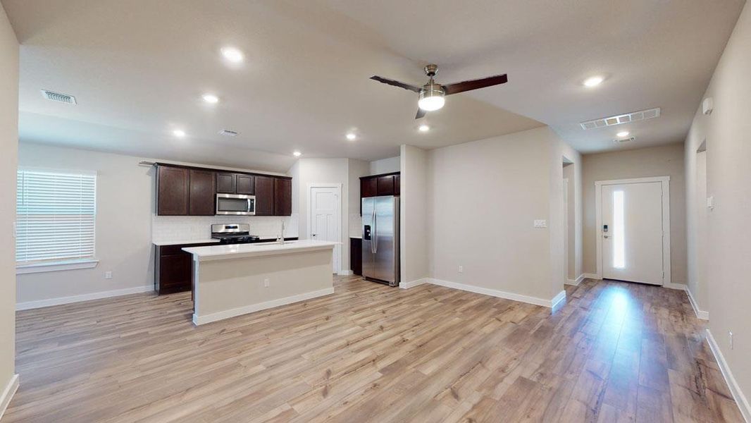 An open-concept living space integrates a well-appointed kitchen with warm wooden floors throughout. An open-concept living space integrates a well-appointed kitchen with warm wooden floors throughout.
