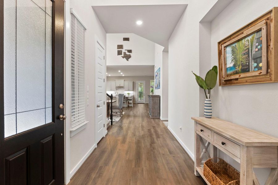Entryway featuring wood-finish flooring, a black paneled door with decorative glass, white walls, recessed lighting, and an open concept layout