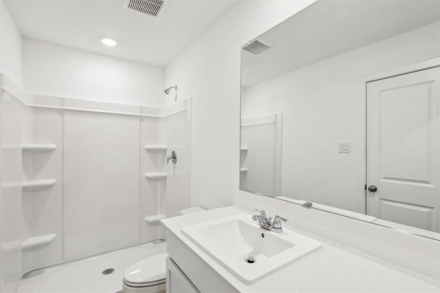 Bathroom featuring a white integrated sink vanity with chrome fixtures and a large wall-mounted mirror