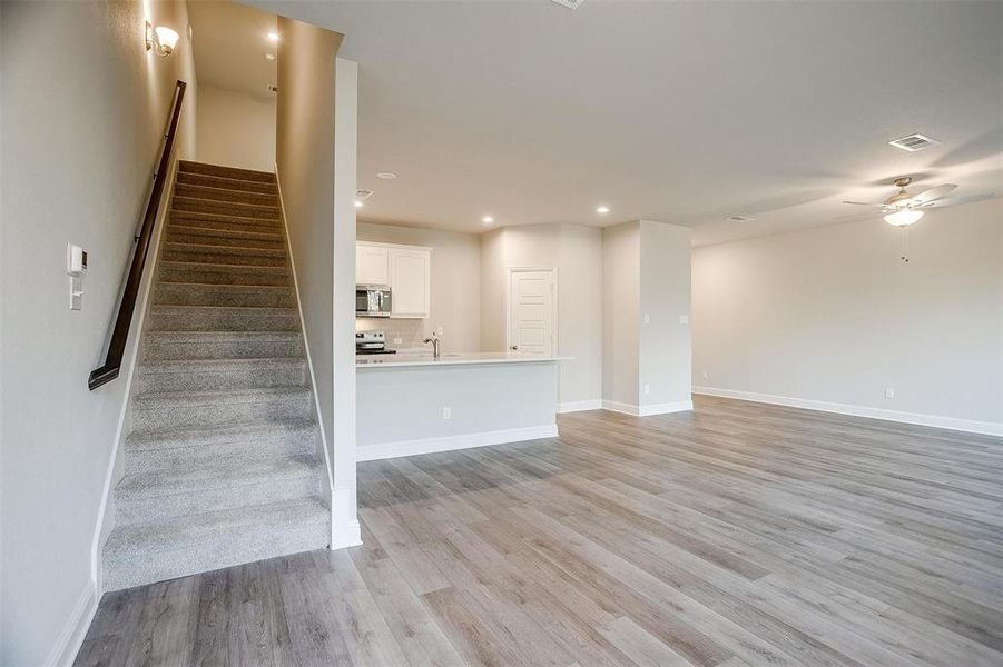 Stairway featuring sink, hardwood / wood-style floors, and ceiling fan