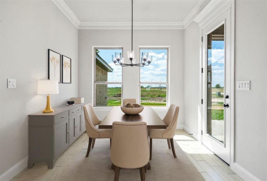 Dining area with healthy amount of natural light, a chandelier, and ornamental molding