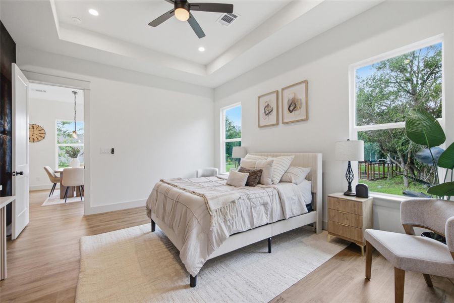A tranquil bedroom features warm wood flooring and a view of the natural outdoors. A tranquil bedroom features warm wood flooring and a view of the natural outdoors.