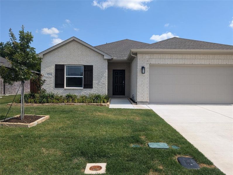 View of front facade featuring a garage and a front yard