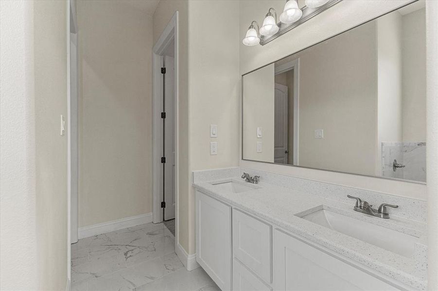 Full bath featuring marble look tiles and double vanity