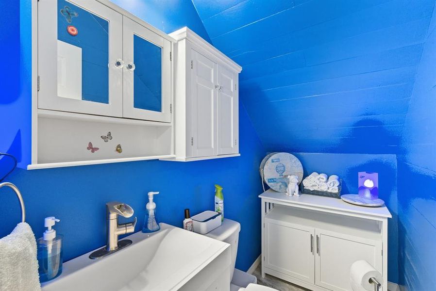 Bathroom with vaulted ceiling and a sink Bathroom with vaulted ceiling and a sink