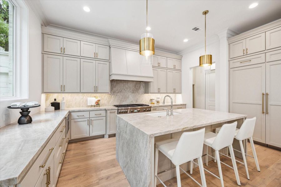The kitchen showcases a premium Thermador appliance package, which includes a 48” Pro Harmony gas range, a 24” built-in MicroDrawer microwave, a 24” custom panel dishwasher, a 30” custom panel fresh food refrigerator, and 30” freezer columns. *Photo is of another home in the community and for informational purposes only.