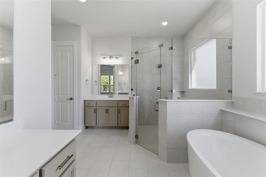 Bathroom with vanity, a shower stall, a freestanding bath, light tile patterned flooring, and recessed lighting