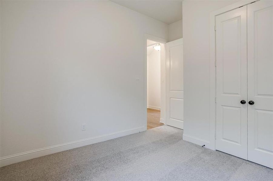 Unfurnished bedroom with a closet and light carpet