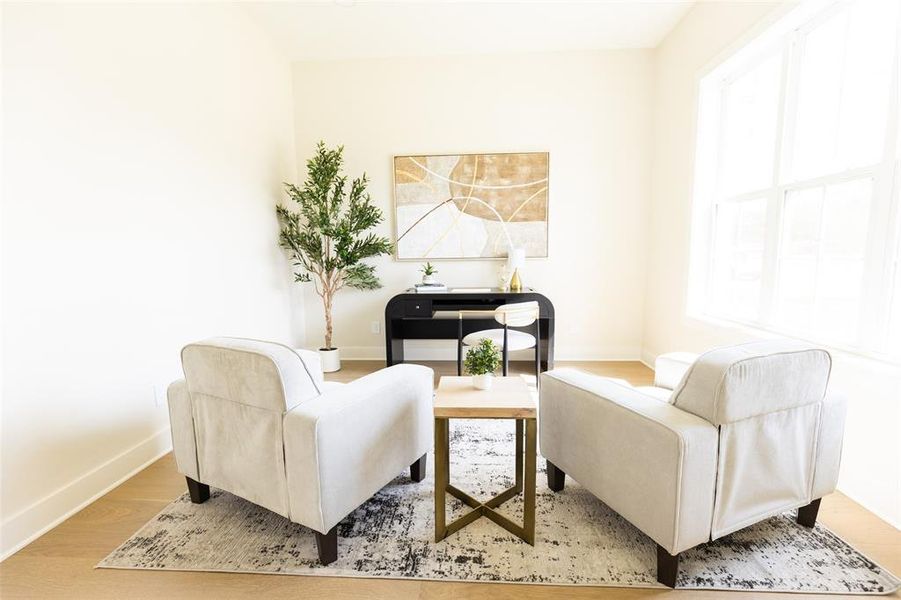 Bright interior space featuring light-toned walls, wood-finish flooring, and a large window