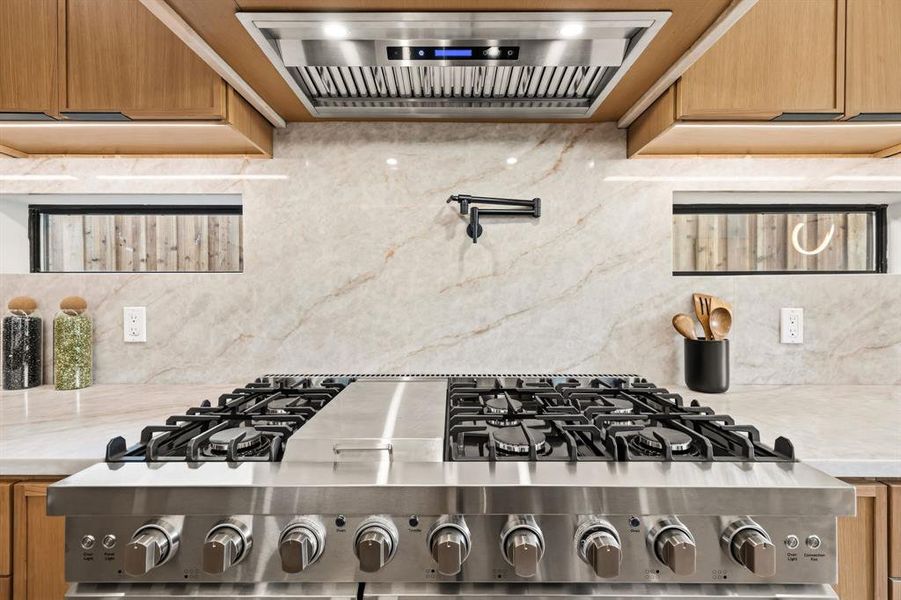 Stainless steel professional-grade range with multiple burners and griddle