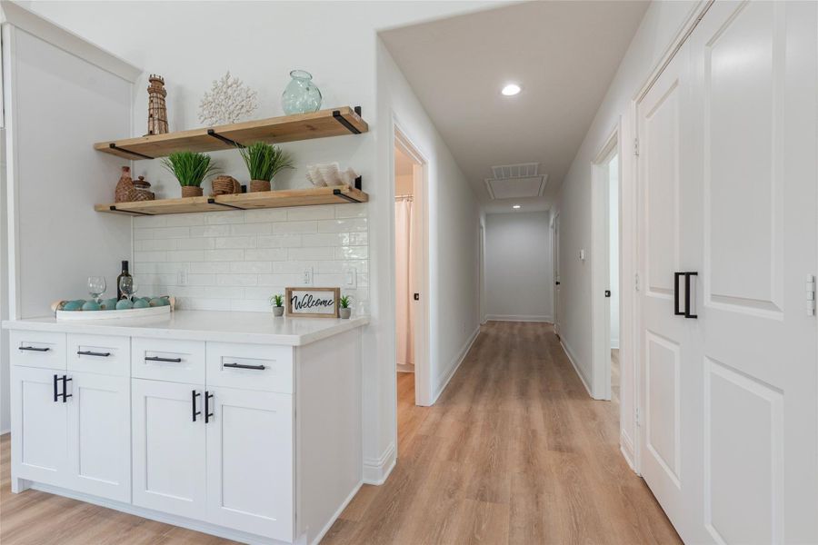 Large walk-in laundry room to the right. Hallway leading to bedrooms and bathrooms areas.