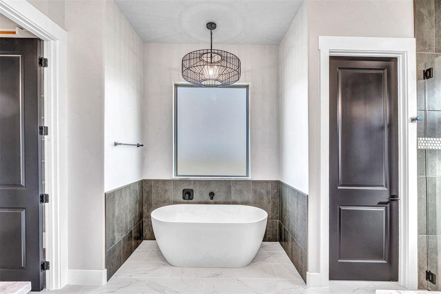 Bathroom featuring separate shower and tub and tile walls