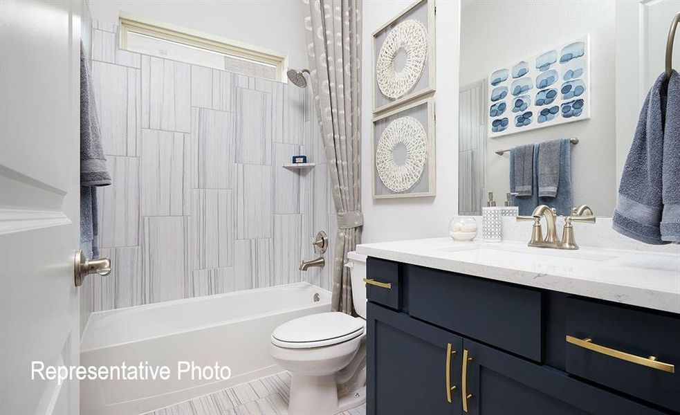 Bathroom featuring a dark blue vanity with gold-tone hardware, a white countertop, and a built-in sink