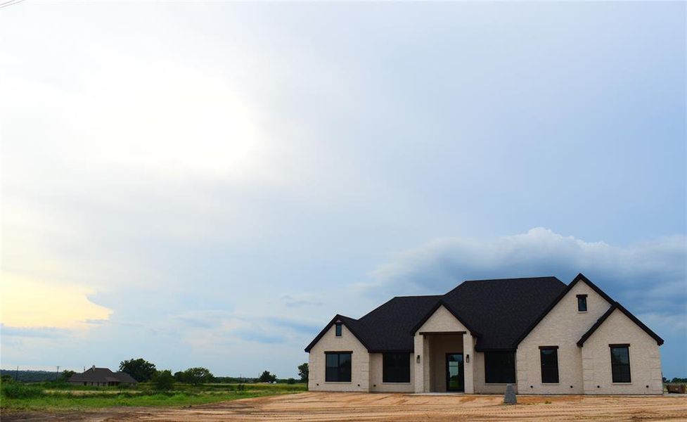 View of front of property featuring brick siding and roof with shingles View of front of property featuring brick siding and roof with shingles
