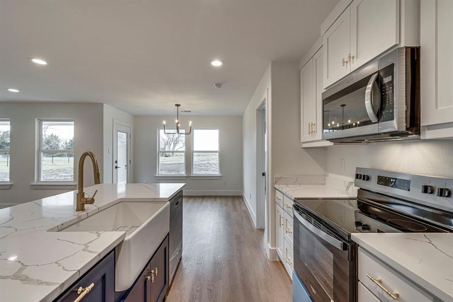 Kitchen featuring white cabinetry, plenty of natural light, and appliances with stainless steel finishes