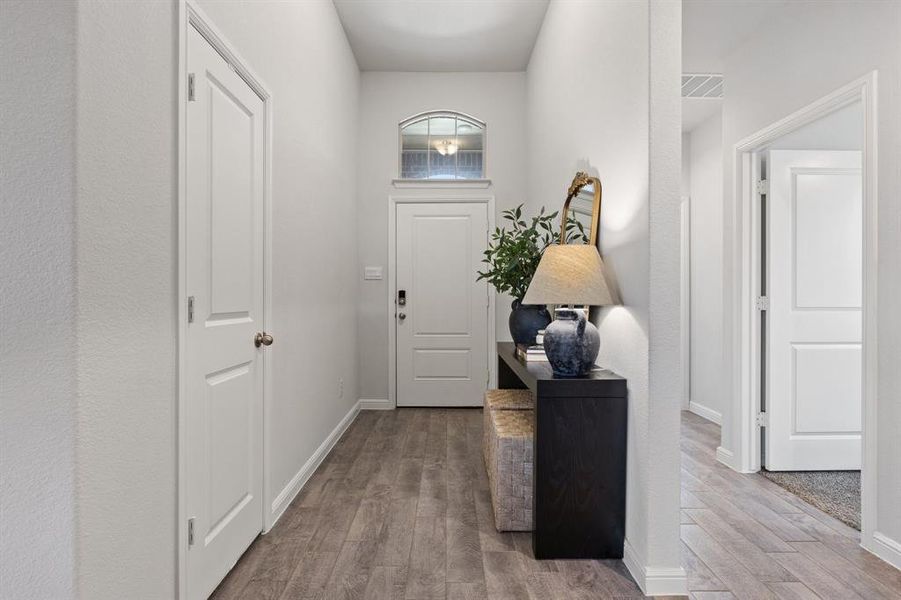 Entrance foyer featuring vinyl wood floors and storage closet Entrance foyer featuring vinyl wood floors and storage closet