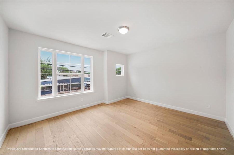 Light and spacious, this larger secondary bedroom at the front of the house shines with an available wood floor upgrade.