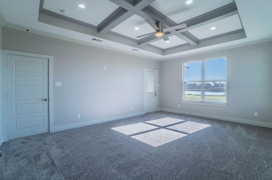 Unfurnished room with crown molding, coffered ceiling, a ceiling fan, carpet flooring, and beamed ceiling