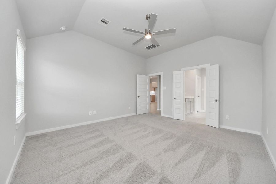 Escape to tranquility in this spacious primary room, adorned with plush carpeting and bathed in the soothing hues of warm paint colors, creating a cozy retreat for relaxation.