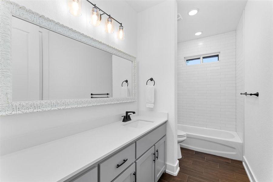 Bathroom with vanity, toilet, wood finished floors, baseboards, and recessed lighting Bathroom with vanity, toilet, wood finished floors, baseboards, and recessed lighting