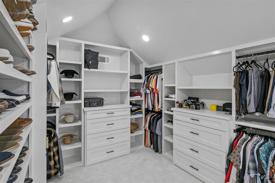 Walk in closet featuring lofted ceiling and light carpet Walk in closet featuring lofted ceiling and light carpet