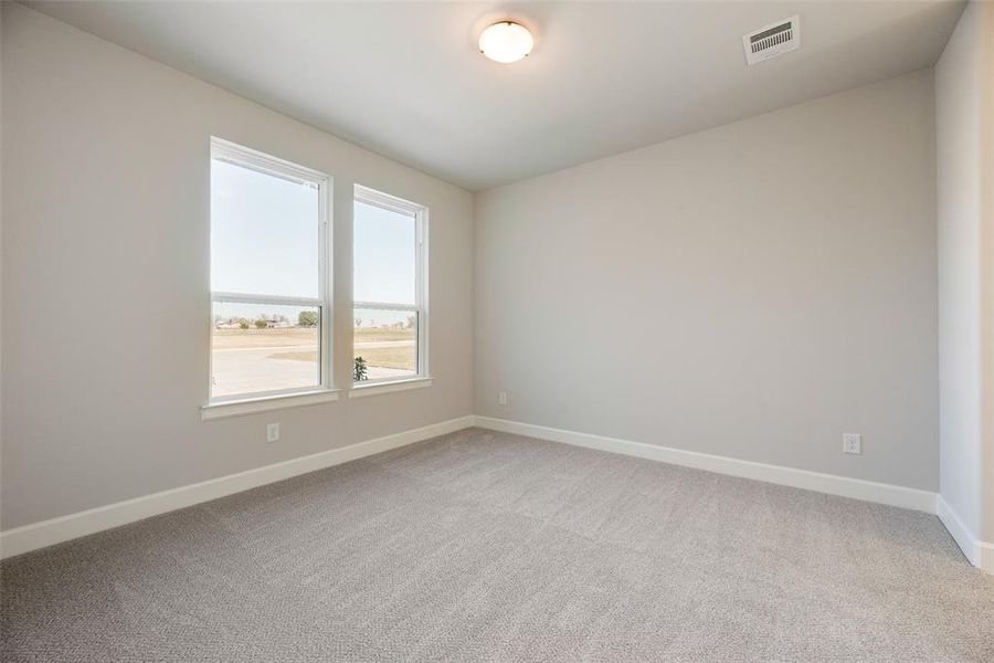 Spare room featuring baseboards and light colored carpet Spare room featuring baseboards and light colored carpet