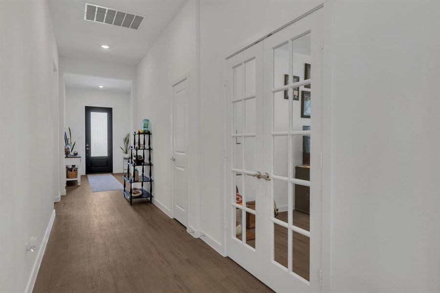 Hallway with dark wood-style floors and recessed lighting