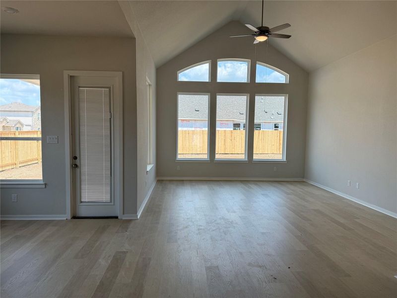 Unfurnished living room featuring light wood finished floors, vaulted ceiling, and a ceiling fan Unfurnished living room featuring light wood finished floors, vaulted ceiling, and a ceiling fan