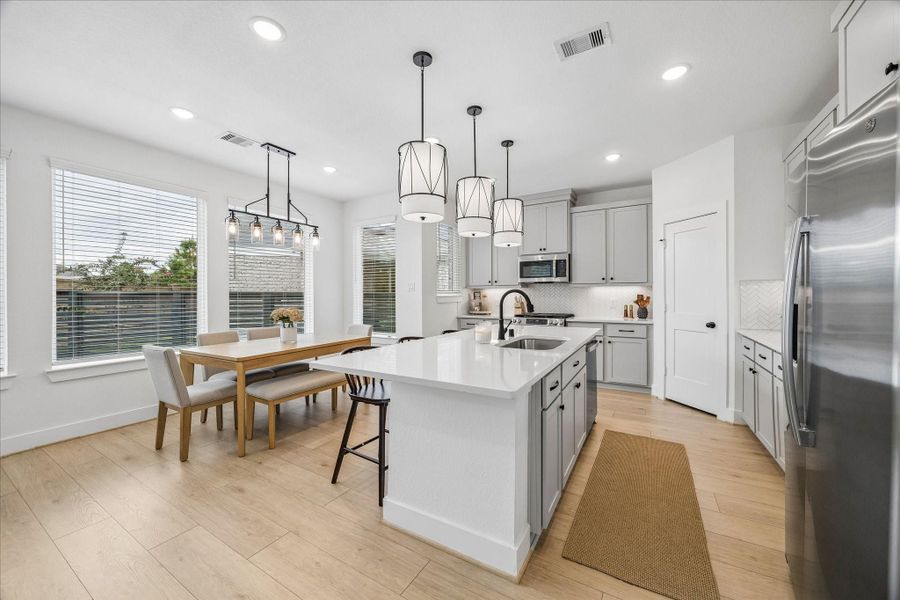 The island kitchen is designed for both style and function, featuring 42-inch cabinetry, quartz countertops, and energy-efficient ENERGY STAR® appliances.