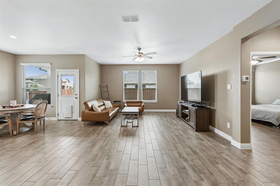 Open-concept living space featuring wood-finish flooring, recessed lighting, and ceiling fans