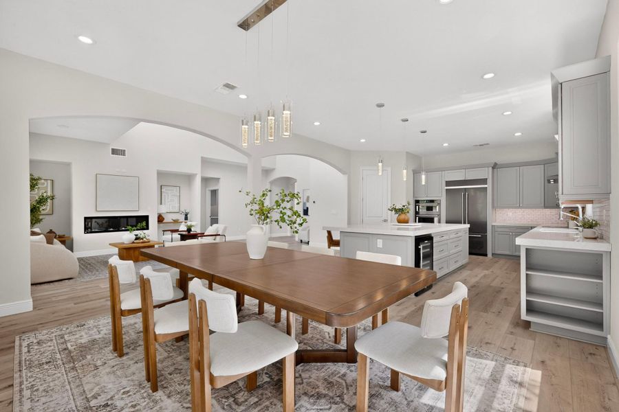 Arched transitions connect this elegant dining space with the kitchen and adjoining living areas.