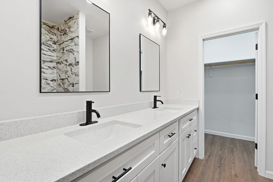 En suite featuring double sinks, modern mirrors and lots of counter space