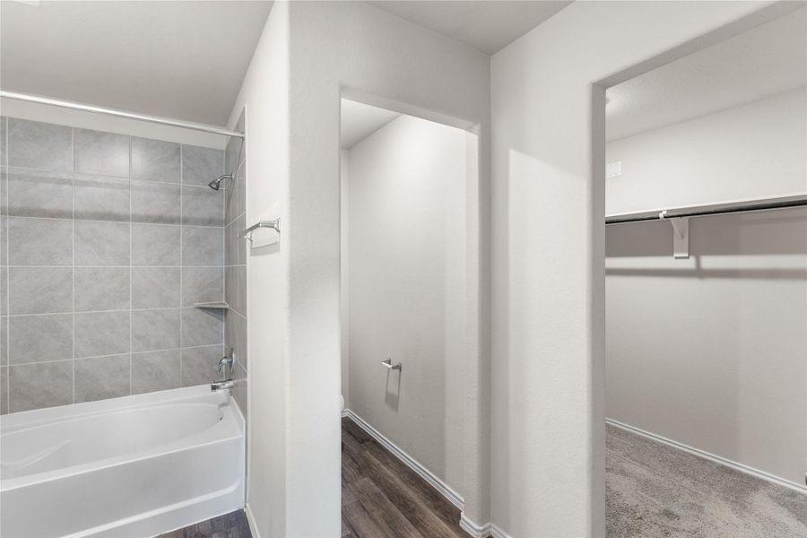 Primary bathroom view with access to walk-in closet and separate water closet. Primary bathroom view with access to walk-in closet and separate water closet.