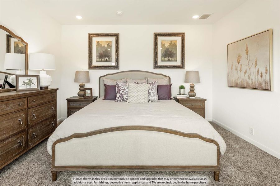 Bedroom with upholstered queen bed, wood dresser, nightstands, and neutral carpet